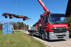 Der LKW-Anhänger wird für das Aufladen des Containers in Position gebracht.