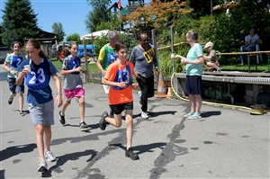 Beim Zieldurchlauf warten Helfer mit Getränkebechern auf durstige Läufer.