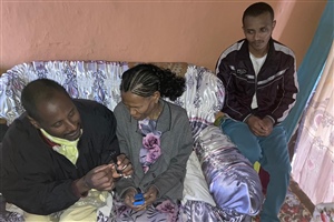 Girma vom MC-Sozialteam erklärt der blinden Ayalnesh (rechts ihr Sohn) die Bedienung des MP3-Players.